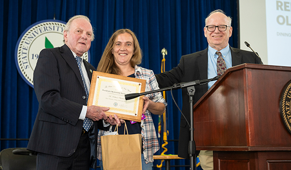 Ronald O'Neill and President Szafran present Rebecca Olmstead with her award.