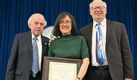 Chairman Ronald O'Neil and President Zvi Szafran present Tess Murphy with the President's Meritorious Service Award.