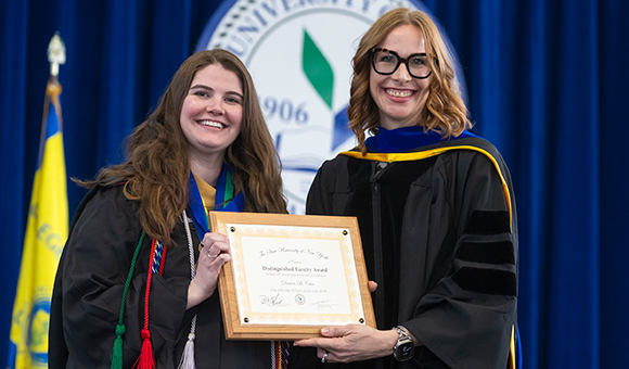 Darien Cain is presented with the 2024 Distinguished Faculty Award from Vice President Lenore VanderZee.