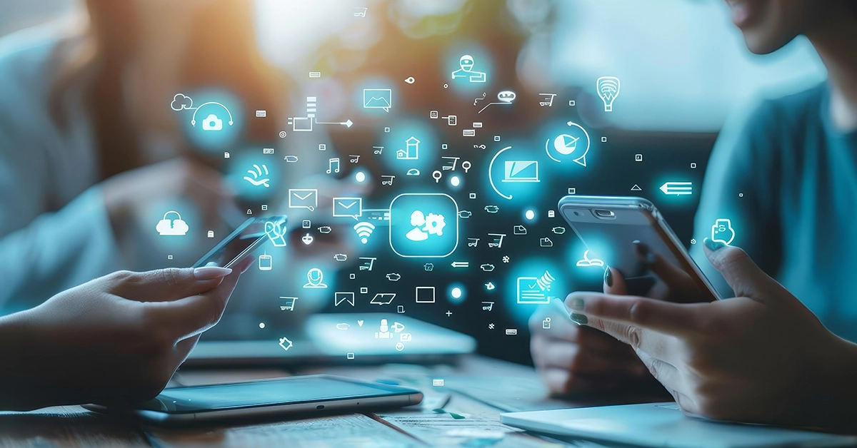 Two people using mobile devices while blue social media icons float between the devices.
