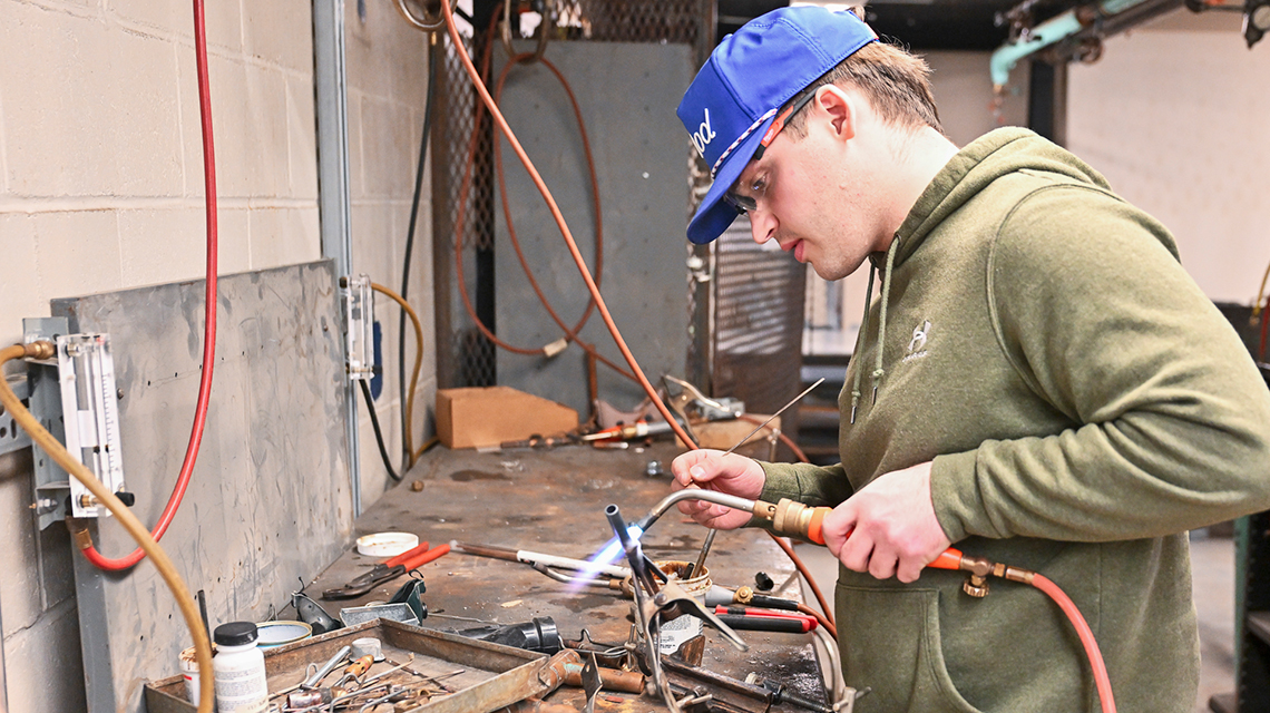 Turner Sochia brazes a piece of copper tubing.