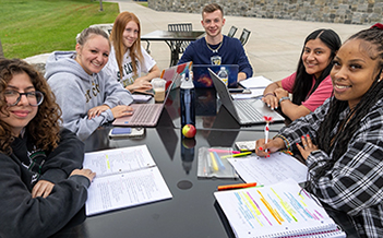 Students study at tables outside Dana Hall.