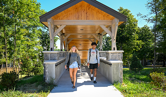 Two students use the new covered walkways connected the residence halls to academic classrooms.