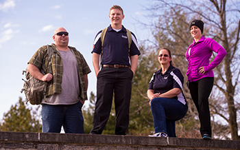 Veterans stand together on a stone wall